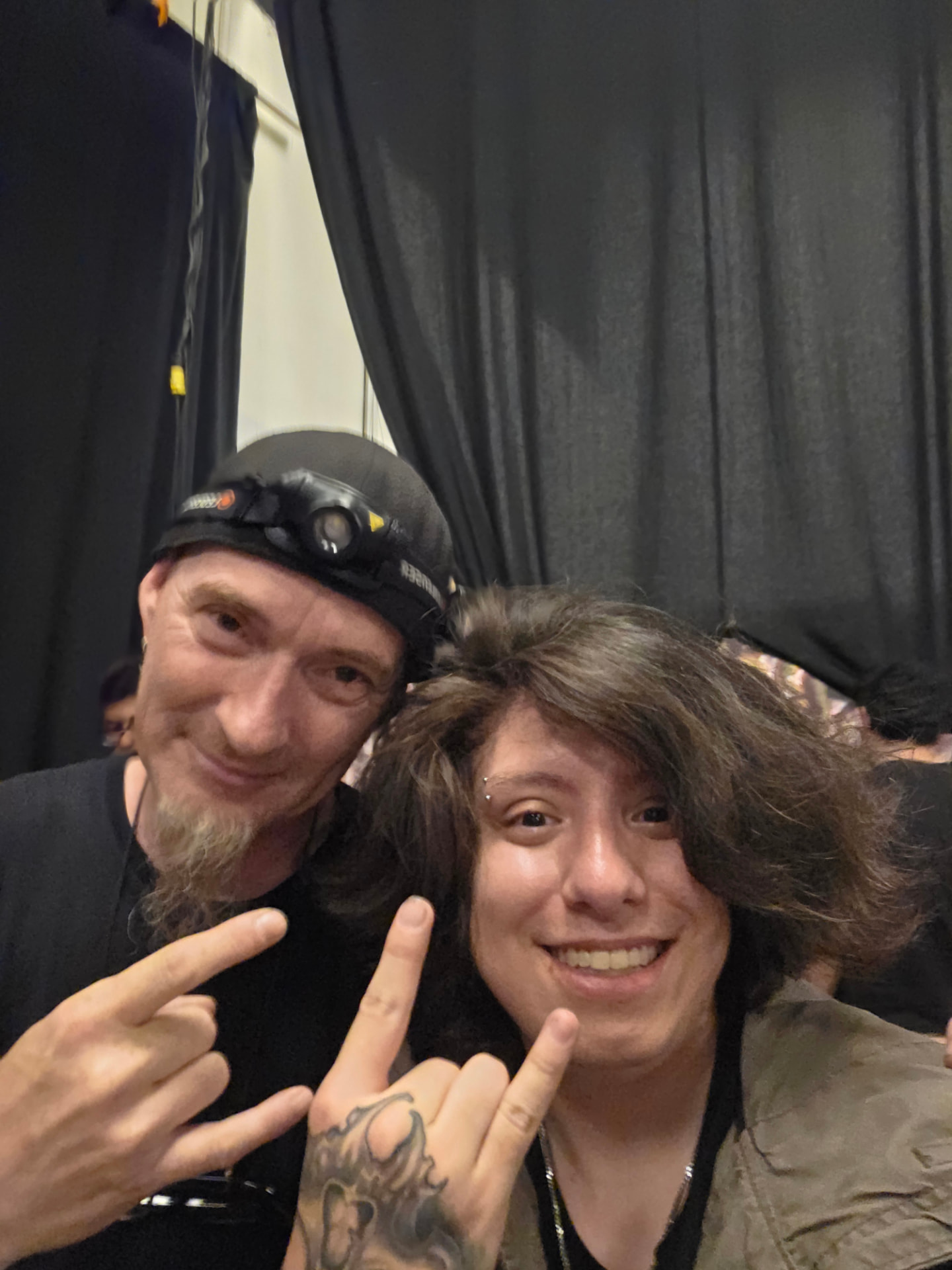 Alex Ripper haciendo cuernos con un músico